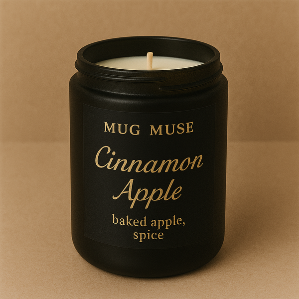 Black candle jar labeled 'Mug Muse Cinnamon Apple' on a brown background